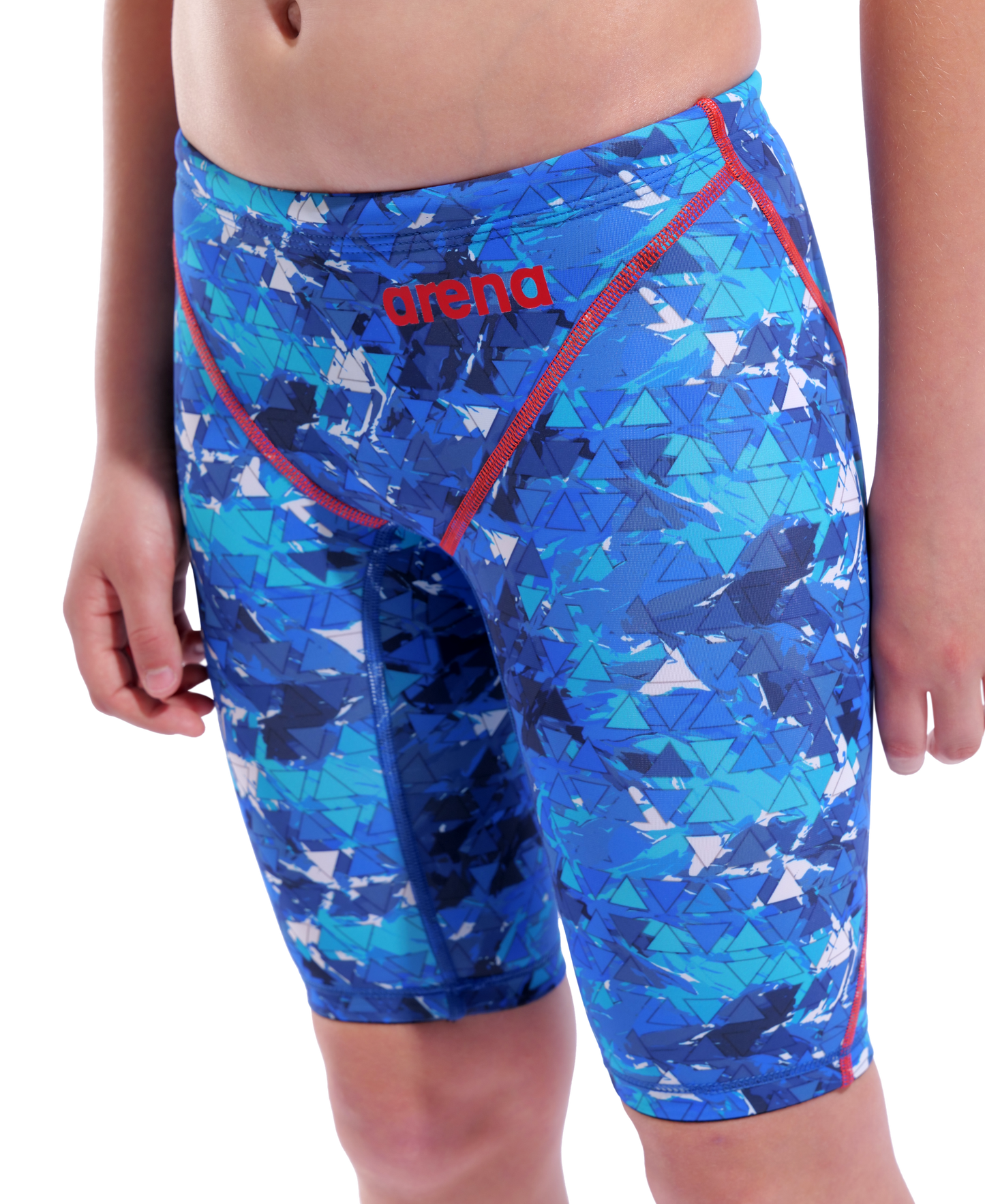 A child wears Arena Boys Powerskin ST Next Jammer - Limited Edition - Splashy, made from recycled fabric with blue geometric patterns, red stitching, and "arena" in red on the waistband. The upper body and head are not visible.