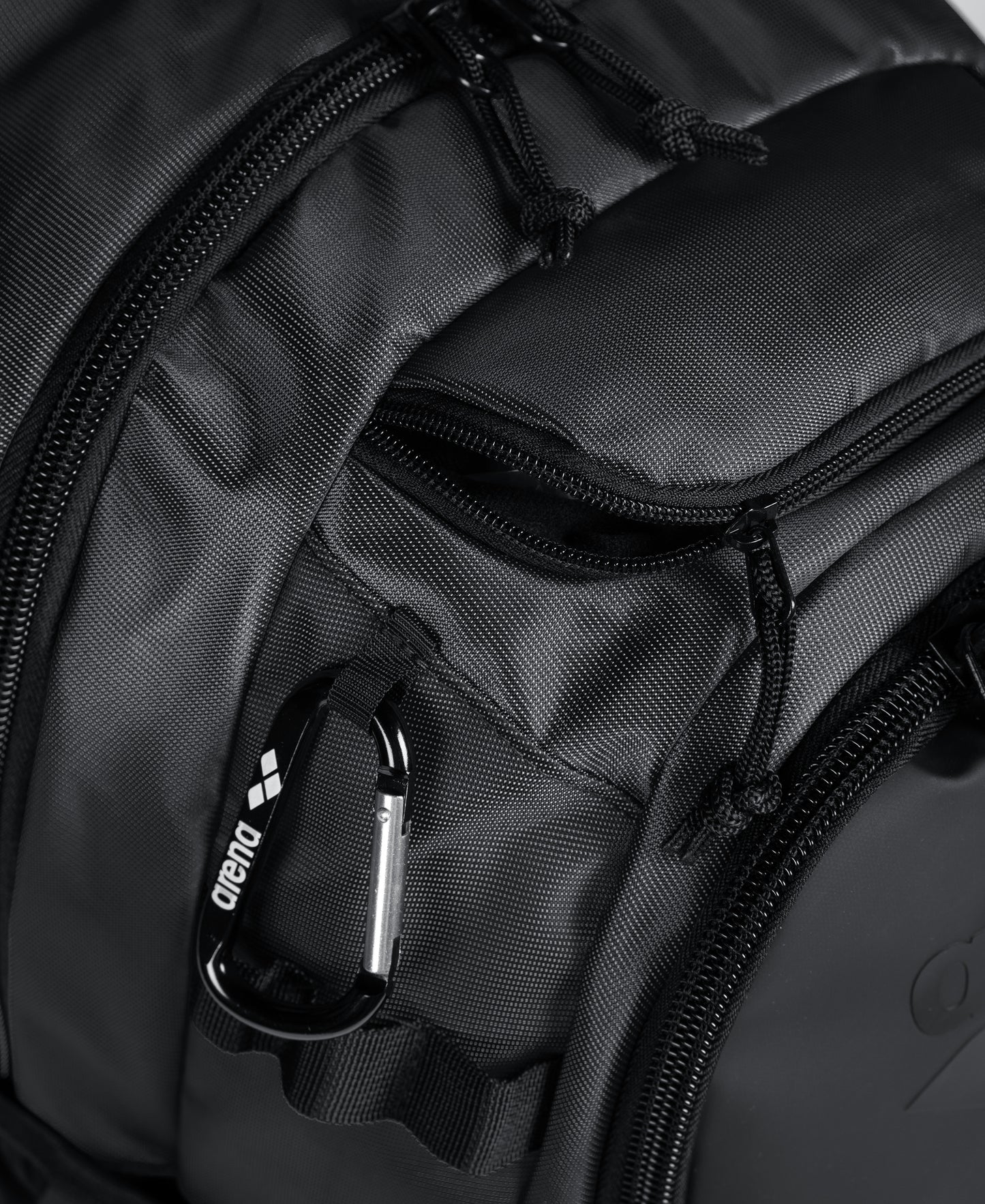 Close-up of the Arena All Set Sports Swim Backpack 45L by Arena, featuring multiple zippered compartments, a black carabiner, and tough textured material—ideal for organizing your sports gear.