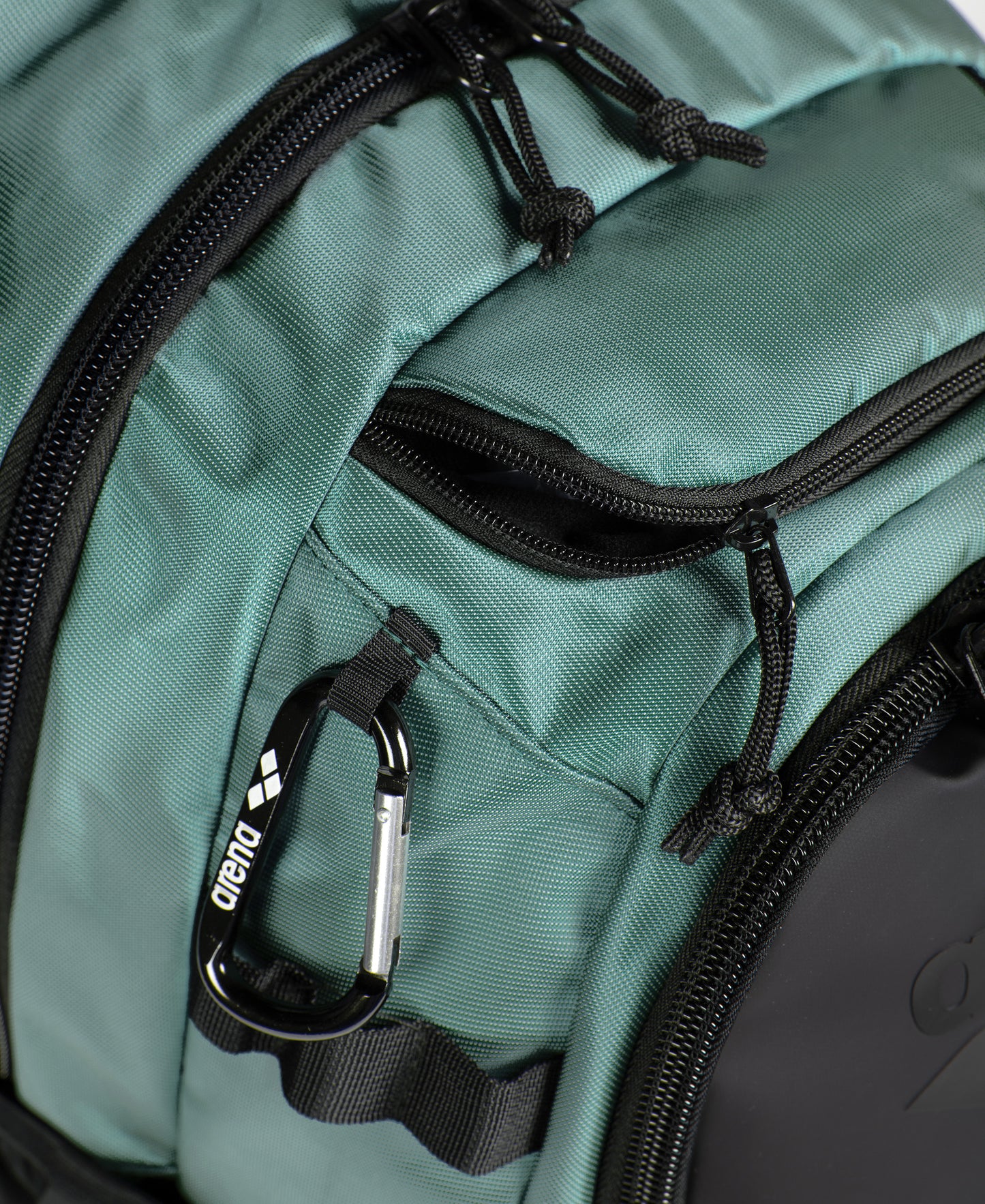 Close-up of the Arena All Set Sports Swim Backpack 45L in Sage, featuring multiple zippered compartments, black zippers, a black and silver Arena carabiner, and a dedicated laptop sleeve for convenience.