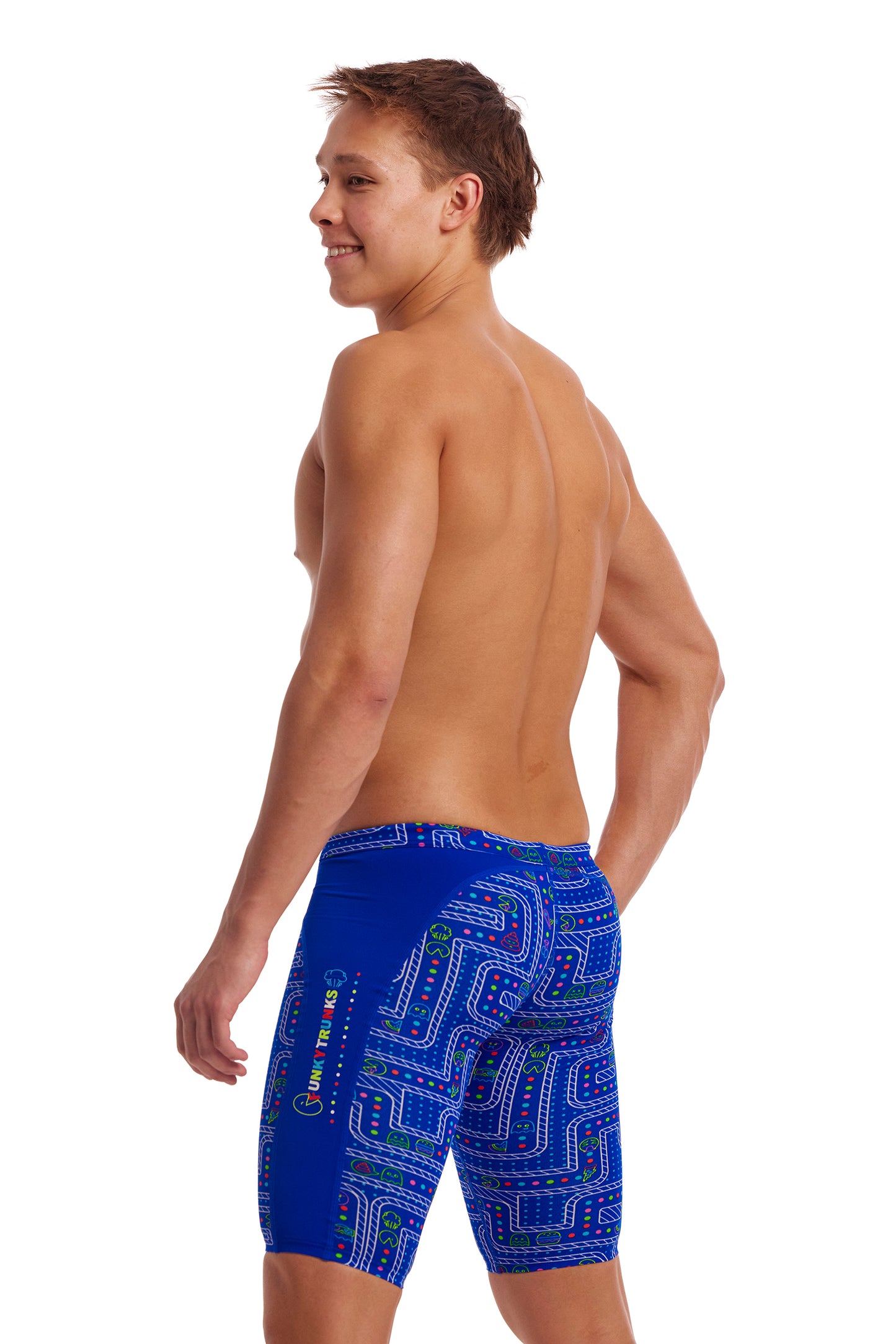 The image shows a male model stood wearing a pair of blue Funky Trunks jammers that have white, green and red detail on them. 